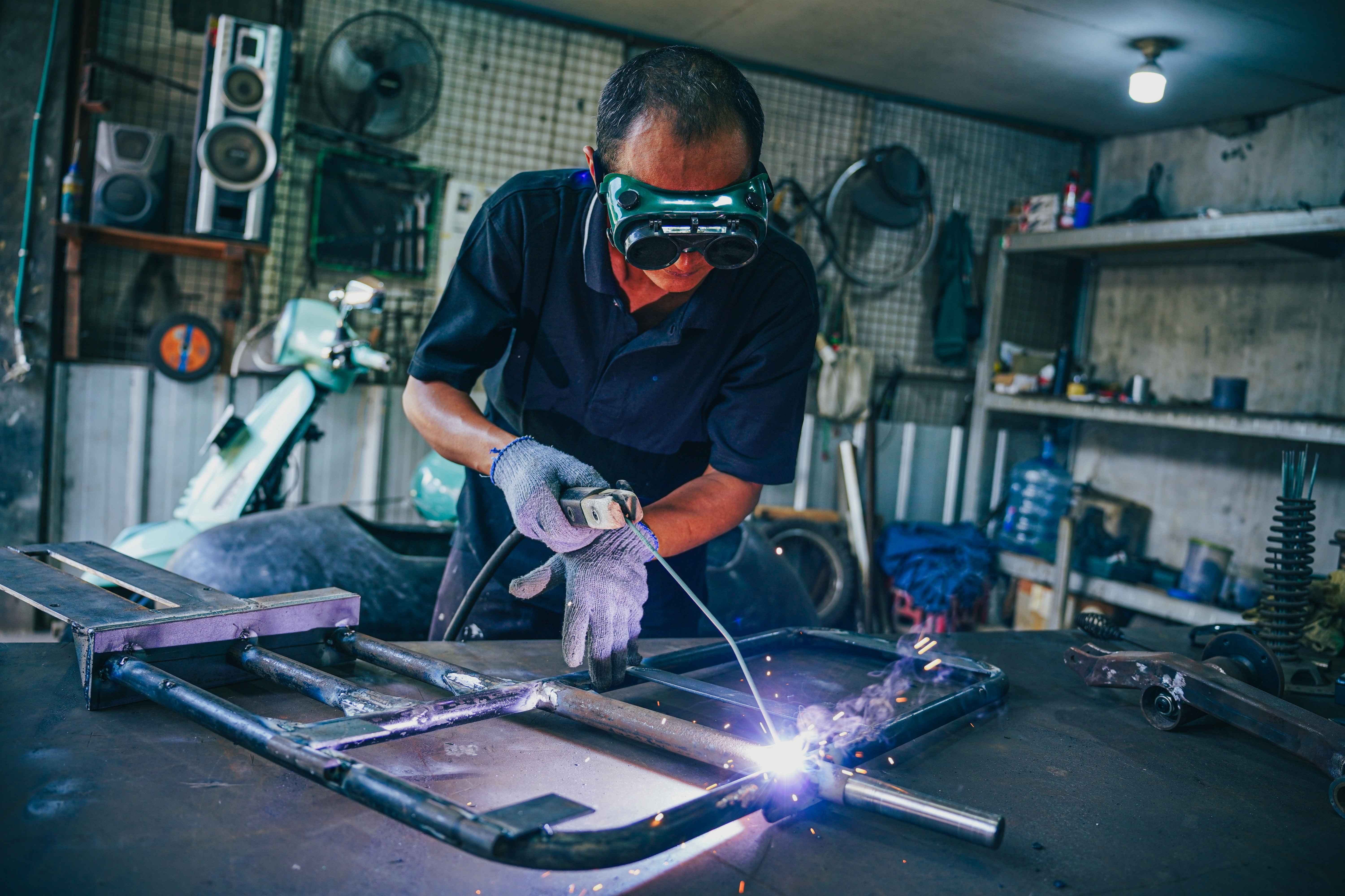 Scooter99 team working focused on a Vespa restoration in a clean workshop environment.